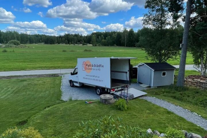 A Flytt och Städfix Mälardalen AB van being unloaded outside a house during a move.