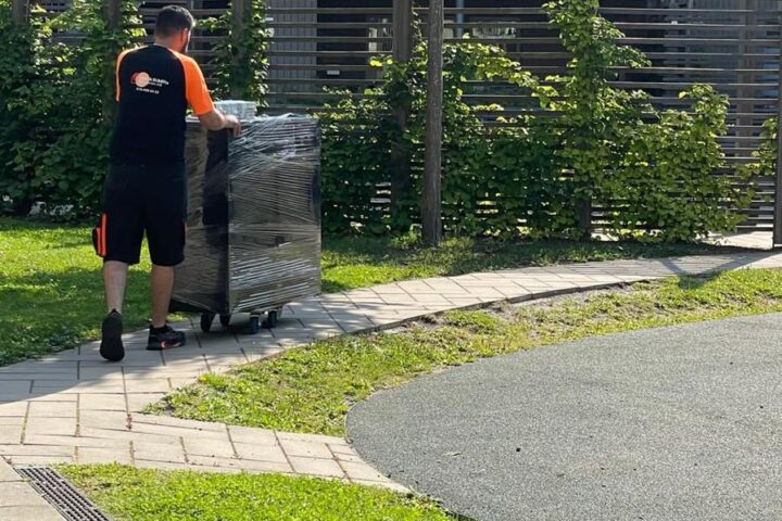 An employee from Flytt & Städfix Mälardalen AB is moving a piece of furniture, which shows professional and careful handling.